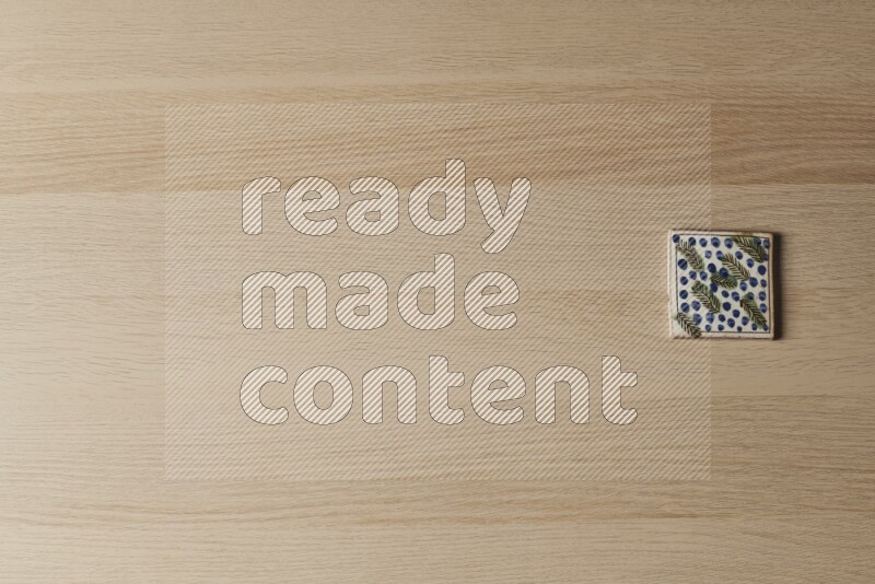 A decorative pottery coaster on light wooden background