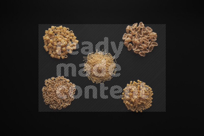 Different pasta types in bunches on black background