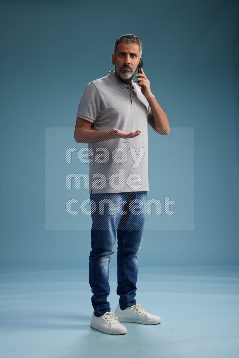 Man Standing talking on phone on blue background