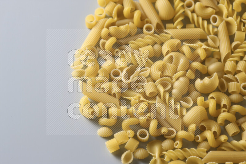 Different pasta types on light blue background