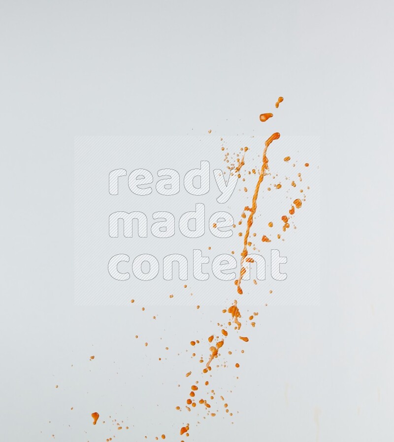 Orange liquid splash and drops on white background