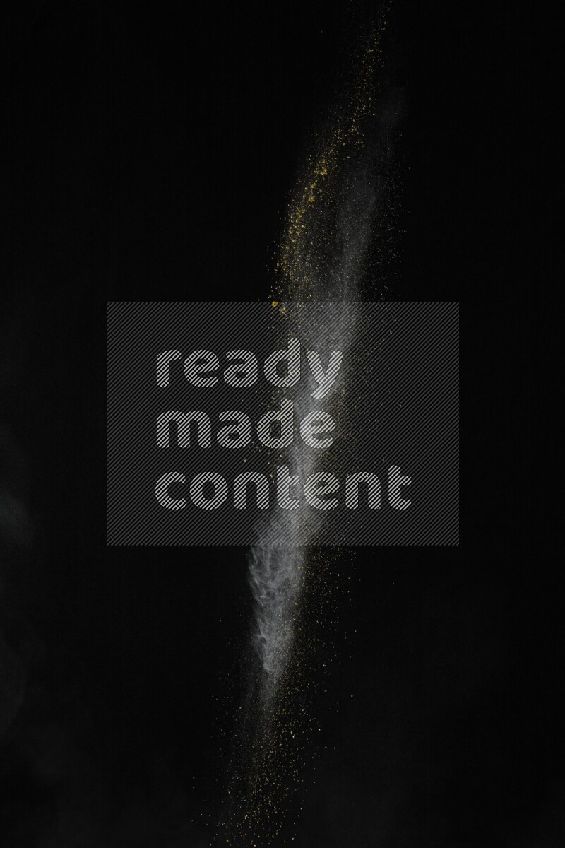 A side view of yellow powder explosion on black background