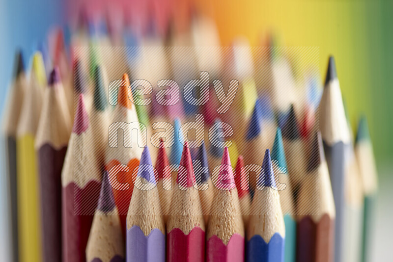 The image captures a close-up of sharpened colored pencils on multicolored background