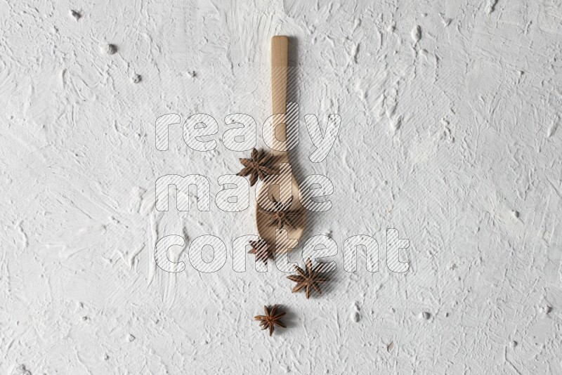Star Anise in a wooden spoon on white flooring