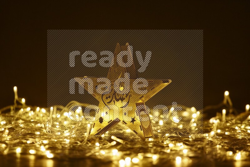 A traditional ramadan lantern surrounded by glowing fairy lights in a dark setup