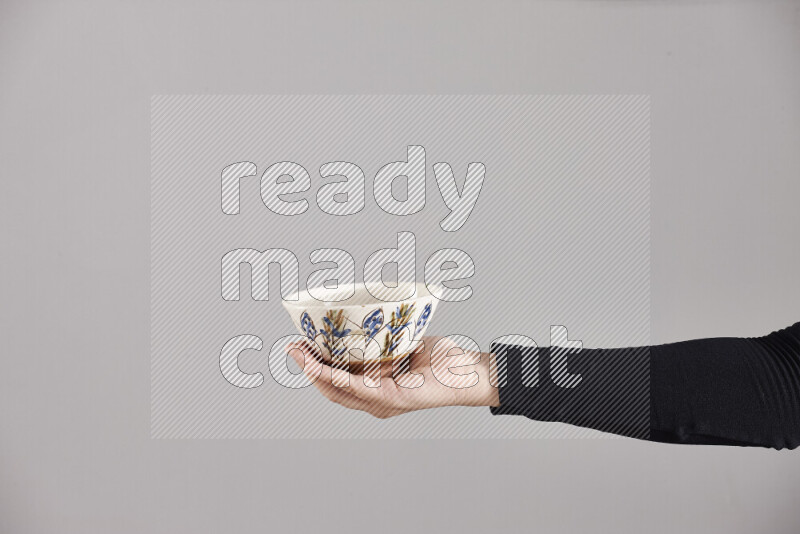 A woman in black abaya holding different pottery essentials in different positions