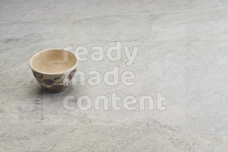 A multicolored pottery bowl on grey marble background