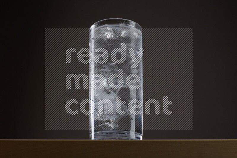 Low angle shot of a glass of water and ice on grey background