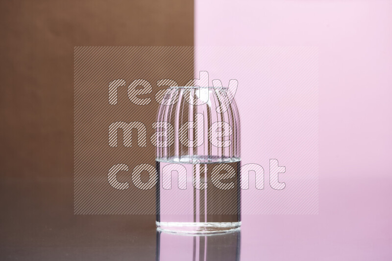 The image features a clear glassware filled with water, set against brown and rose background