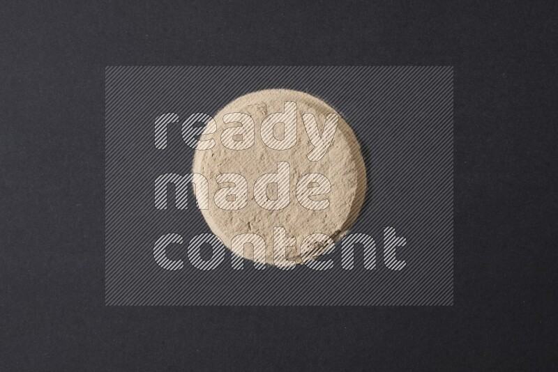 كومة من بودرة الثوم في شكل دائري علي خلفية سوداء