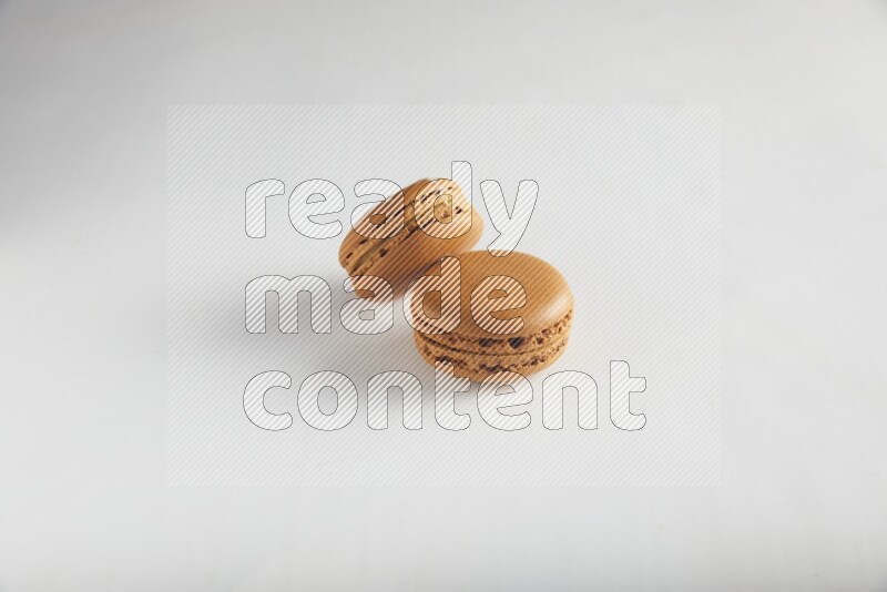 45º Shot of of two assorted Brown Irish Cream, and Brown Maple Taffy macarons  on white background