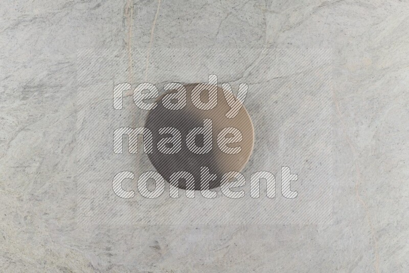 A multicolored pottery plate on grey marble background
