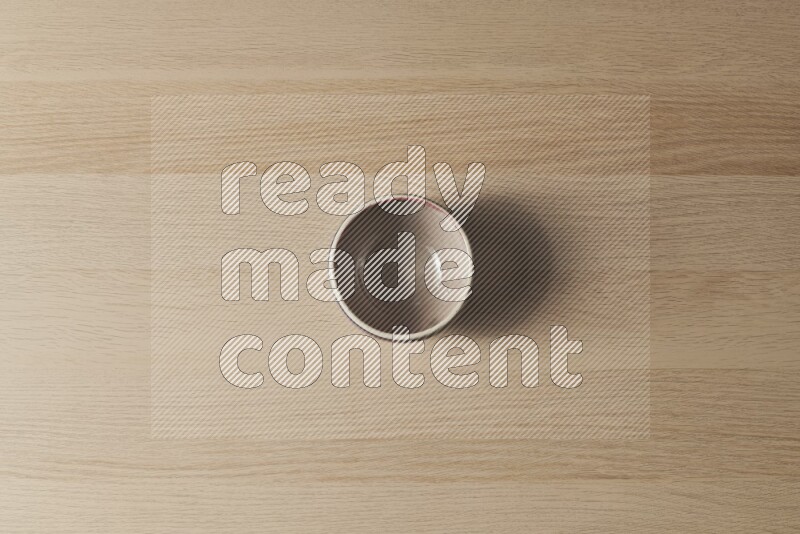 A multicolored pottery bowl on light wooden background