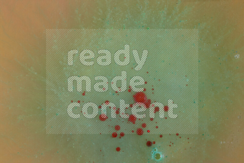 The image captures a dramatic splatter of red, green and yellow paints over the backdrop