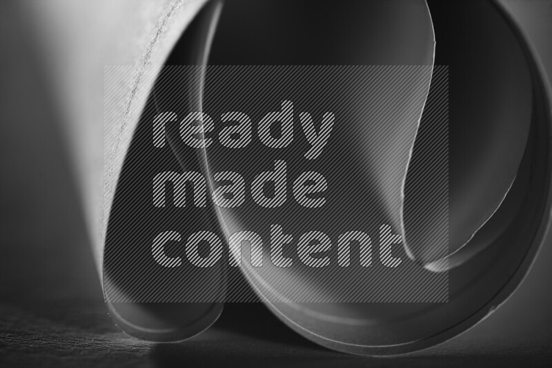 An abstract art piece displaying smooth curves in grey gradients created by colored light