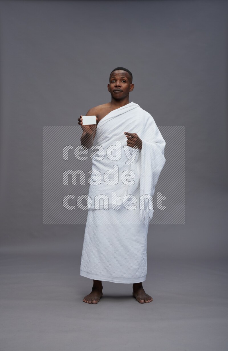 A man wearing Ehram Standing holding ATM card on gray background