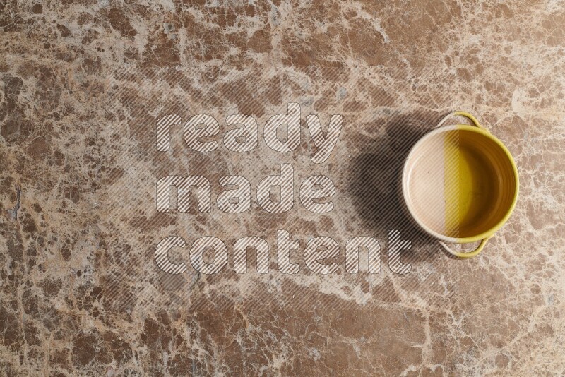 A multicolored pottery bowl on beige marble background