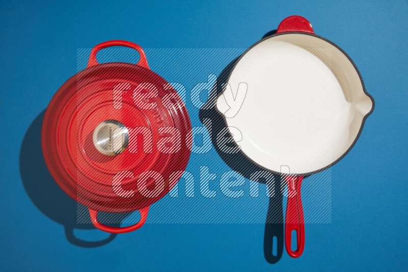 red and white pan and pot on blue background