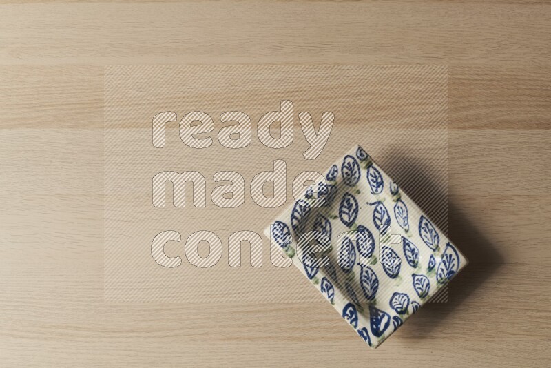 A decorative pottery plate on light wooden background