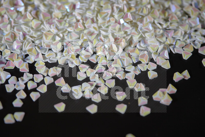 Colorful plastic shards for decoration scattered on a black background