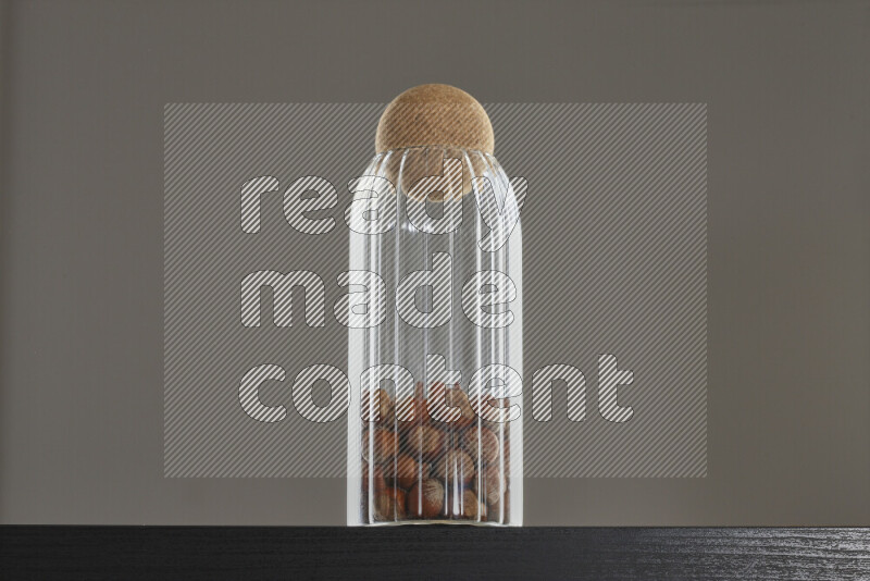 Hazelnuts in a glass jar on black background