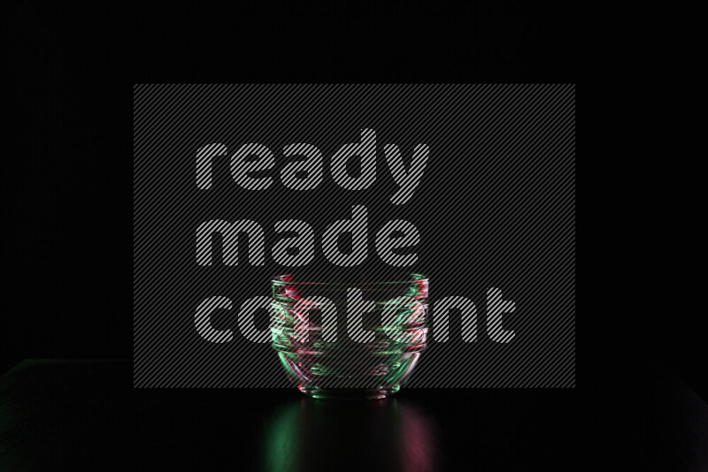 Glassware with rim light in red and green against black background