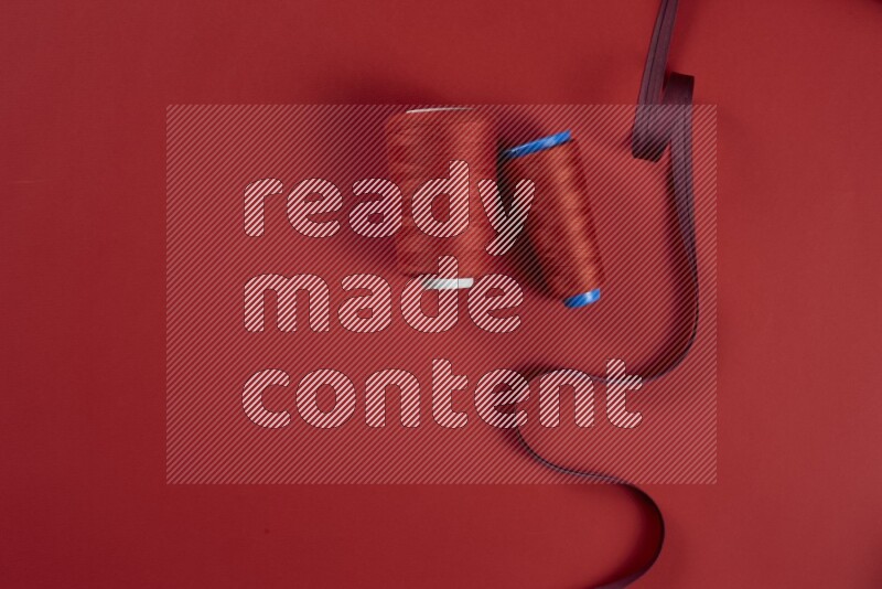 A red collection of sewing and tailoring tools arranged on a red background