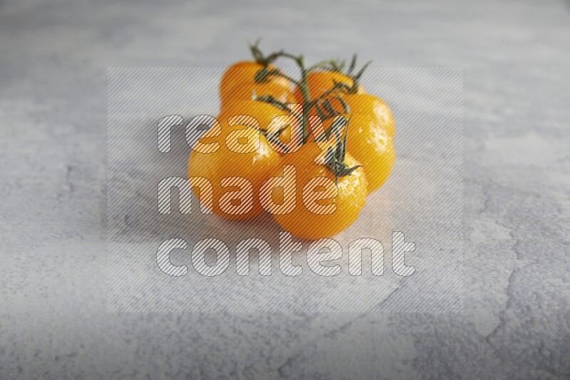 Yellow cherry tomato vein on a light grey textured background 45 degree