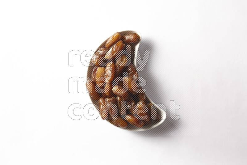 Dates in a crescent pottery plate on white background