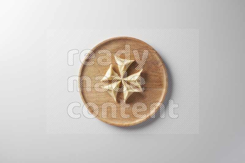 Five Sambosas on a wooden round plate on a white background