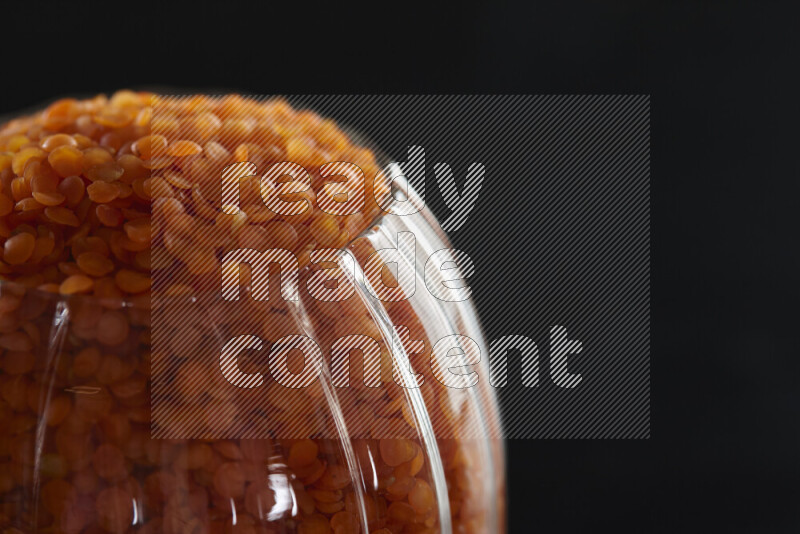 Lentils in a glass jar on black background
