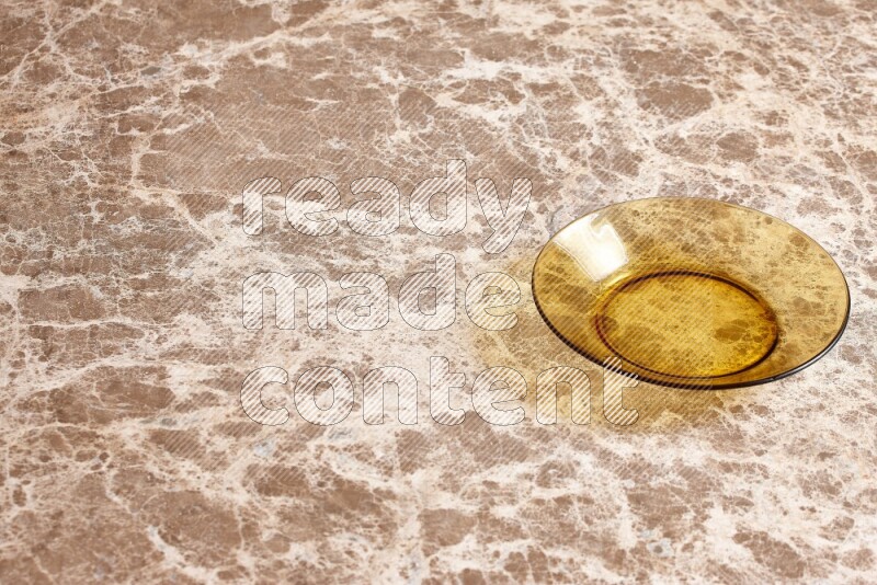 A circular glass plate on beige marble background