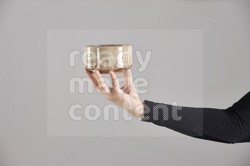 A woman in black abaya holding different pottery essentials in different positions