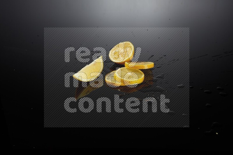 Lemon slices with water drops, and droplets on black background