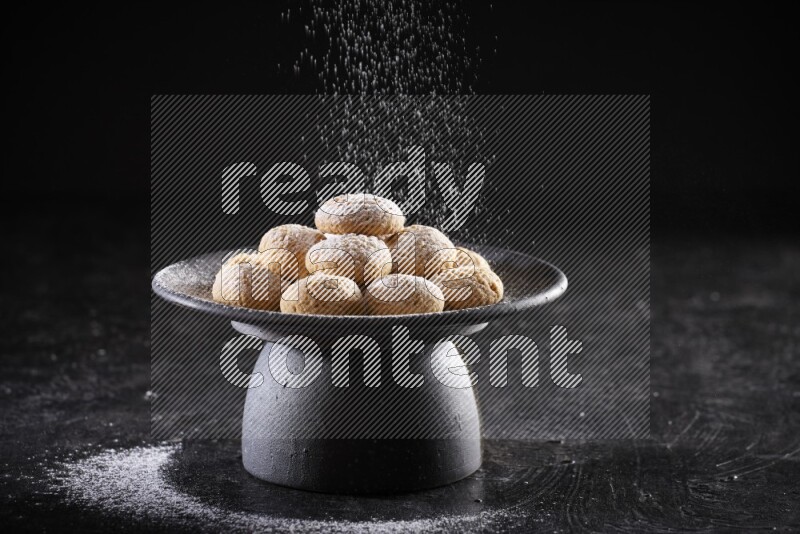Kahk on a serving plate on a black background