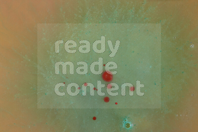 The image captures a dramatic splatter of red, green and yellow paints over the backdrop