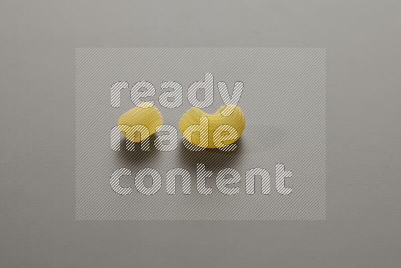 Big rings pasta with other types of pasta on grey background