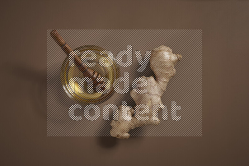 Fresh ginger root with different ingredients such as lemon, orange, honey, ground ginger on beige baackground