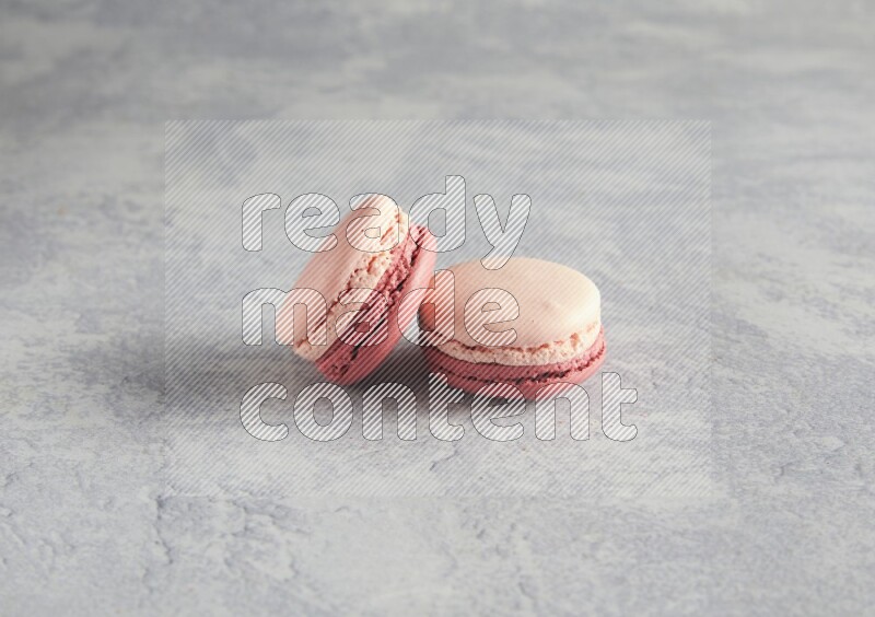 45º Shot of two Pink Litchi Raspberry macarons  on white  marble background