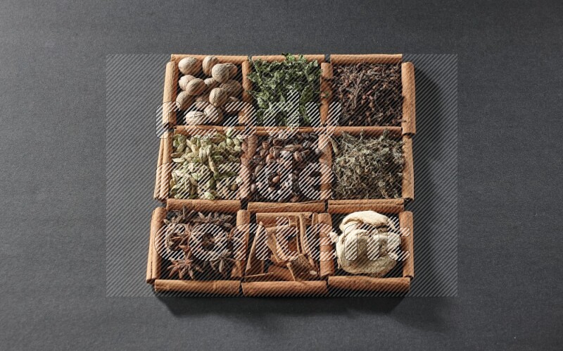 9 مربعات من أعواد القرفة ممتلئة بحبوب القهوة في المنتصف محاطة بجوزة الطيب والنعناع المجفف والقرنفل والريحان المجفف والزنجبيل المجفف والقرفة واليانسون والهيل على أرضية سوداء