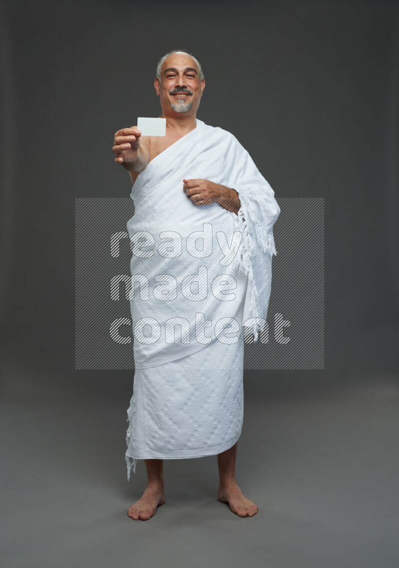 A man wearing Ehram Standing holding ATM card on gray background