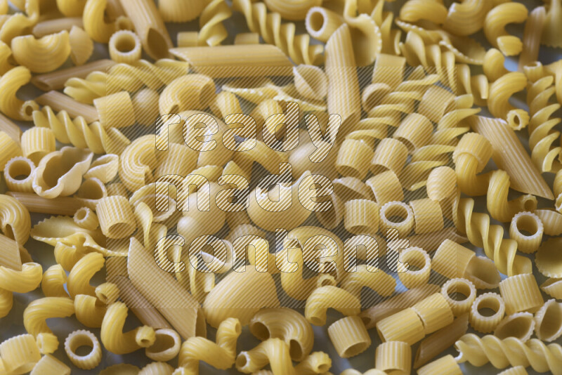Different pasta types on light blue background