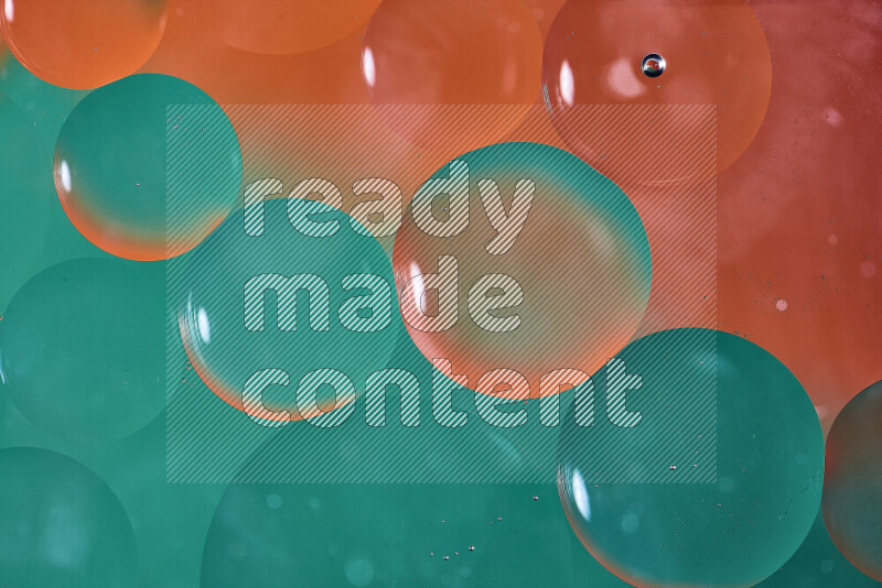Close-ups of abstract oil bubbles on water surface in shades of green and orange