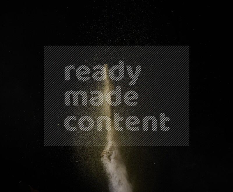 A side view of brown powder explosion on black background