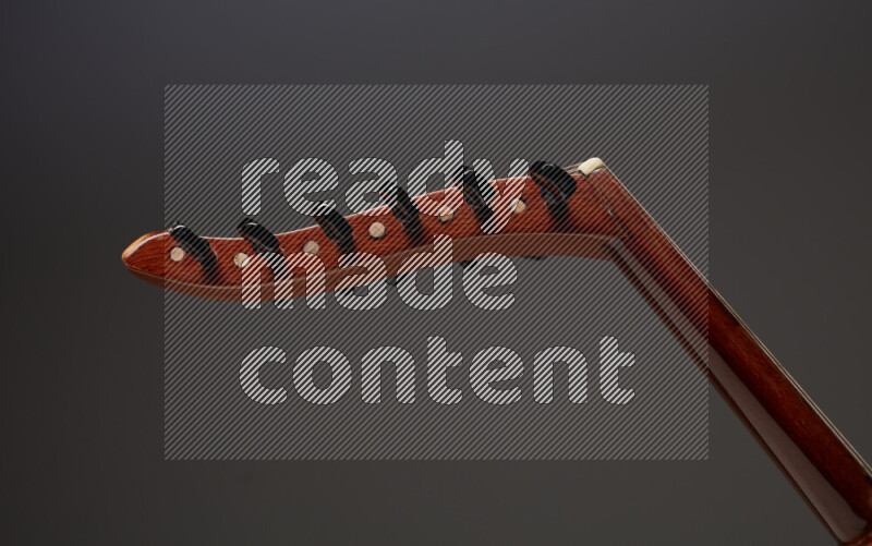 parts of a brown wooden Oud in a gray background