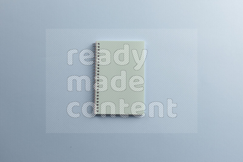 A blue notebook with different school supplies on blue background