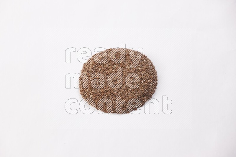 Flax seeds in a circle shape on a white flooring