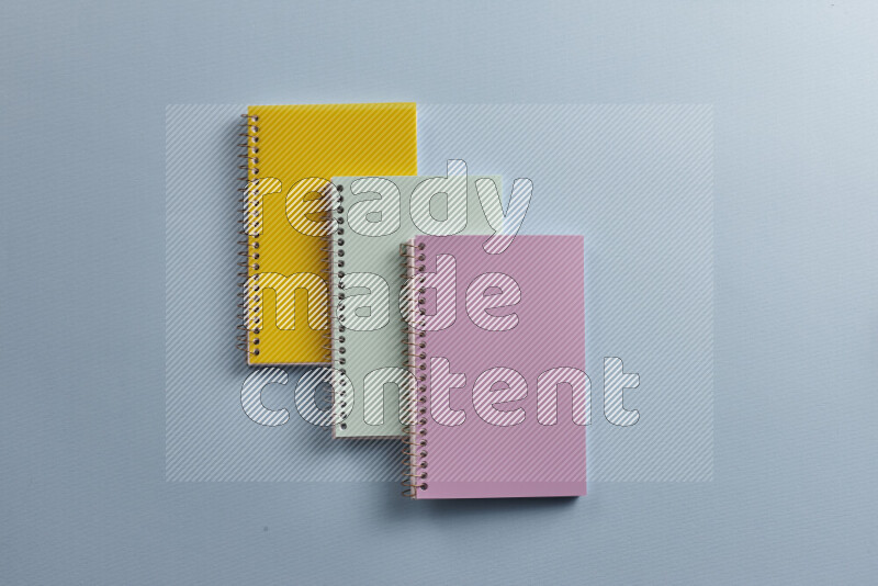 Multicolored notebooks with different school supplies on blue background