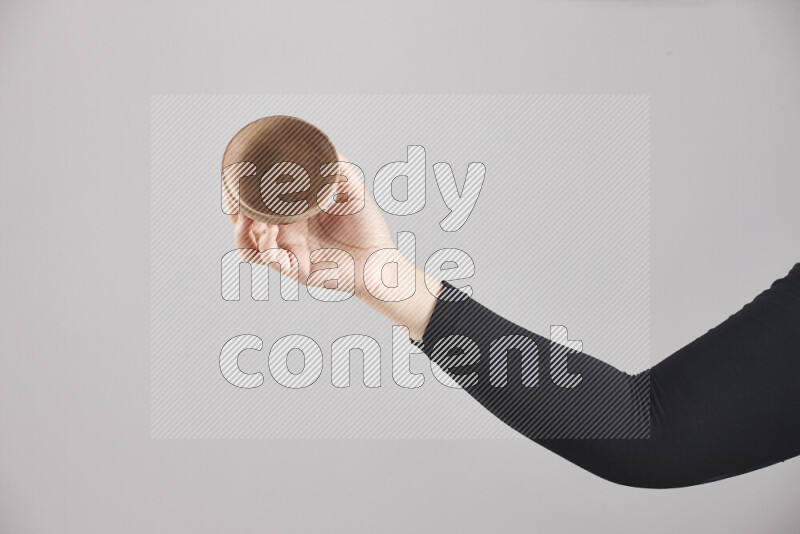A woman in black abaya holding different wooden essentials in different positions