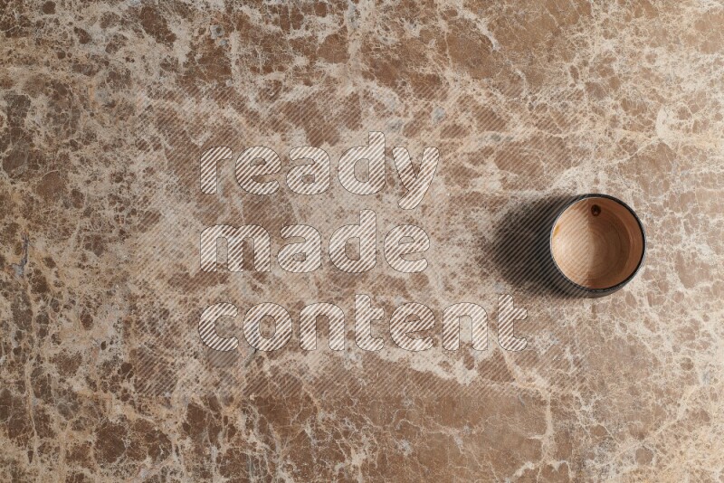 A multicolored pottery bowl on beige marble background